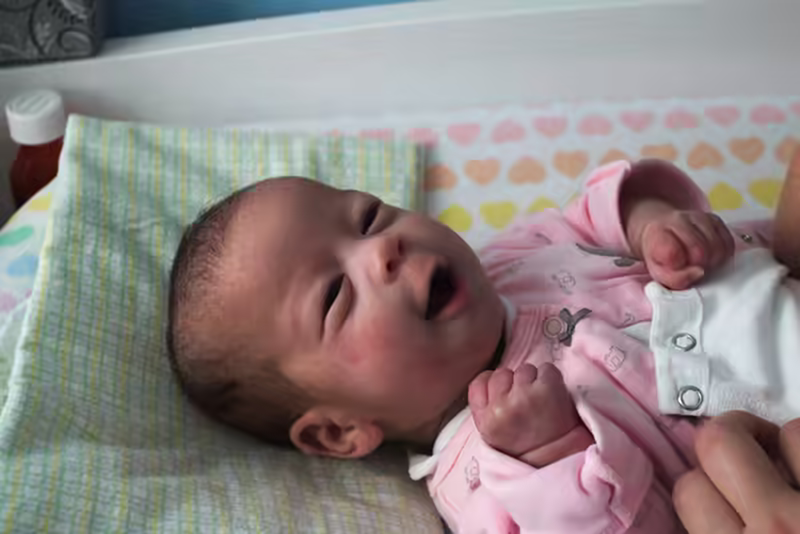 Stella smiles during a diaper change.