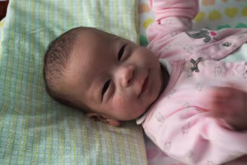 Stella smiles during a diaper change.