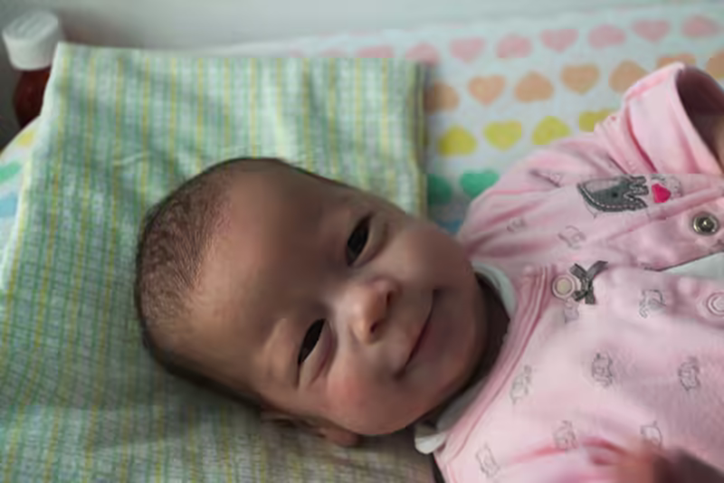 Stella smiles during a diaper change.