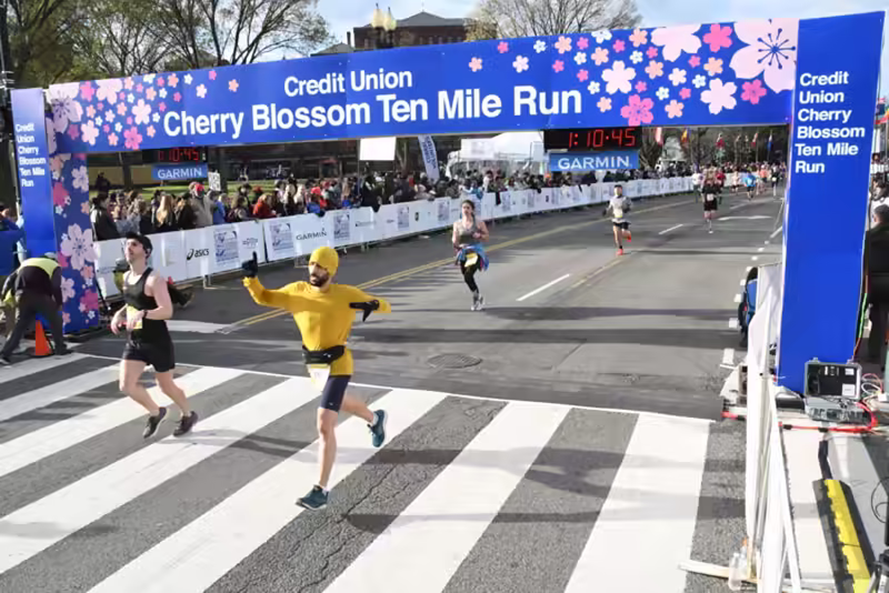 me crossing the finish line with another person. Other runners behind