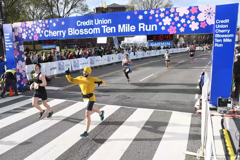 me crossing the finish line with another person. Other runners behind