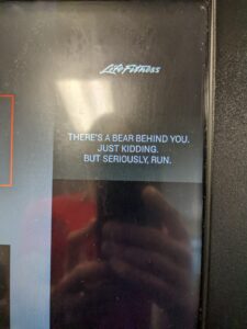 a treadmill that has a message "There's a bear behind you. Just kidding. But seriously, run"